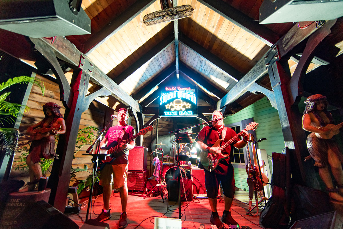 A band performing on stage at the World Famous Square Grouper Tiki Bar