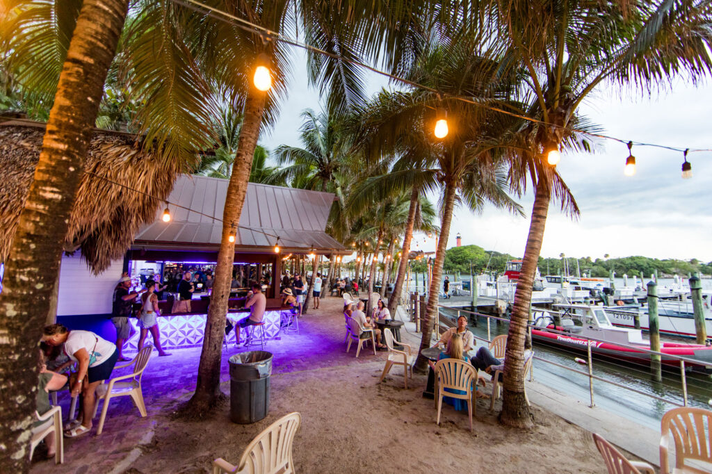 Wide photo from the side bar at Square Grouper Tiki Bar on the Jupiter Inlet with the Jupiter lighthouse in the distance